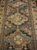 A Caucasian runner, the central panel set with repeating medallions on a dark brown ground,