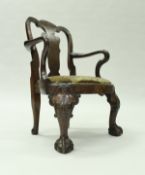 An early 18th Century walnut veneered childs elbow chair in the Queen Anne taste raised on shell