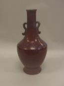 A Chinese sang de boeuf glazed twin handled vase bearing faux Daoguang seal mark to base,