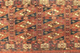 A Bokhara Torba rug with all over repeating design on a dark red ground,