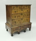 An 18th Century walnut chest of two short on three long graduated drawers upon a base of three
