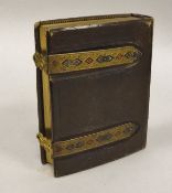 A Victorian leather bound photograph album with embossed metal mounts containing photographs of