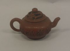 A Chinese Yixing teapot, the reticulated cover of branch and floral design,