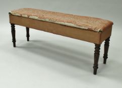 A Victorian upholstered box seat window seat on turned mahogany legs,