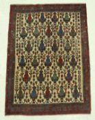 A Caucasian rug, the central panel set with repeating vase decoration on a fawn ground,