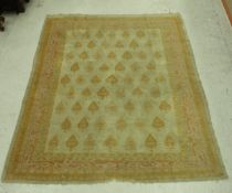 A Turkish style rug, the central panel set with repeating floral hook motifs on a cream ground,