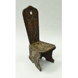 An early 20th Century carved oak spinning chair with carved dove decoration on plank end supports