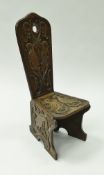 An early 20th Century carved oak spinning chair with carved dove decoration on plank end supports