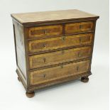 A walnut veneered chest of drawers in the 18th Century manner, the plain top with inlaid decoration,