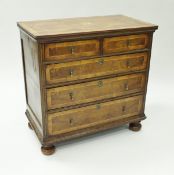 A walnut veneered chest of drawers in the 18th Century manner, the plain top with inlaid decoration,
