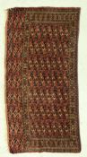 A Bokhara Torba rug, the main panel set with repeating tile design on a dark red ground,