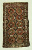 A Kazak rug, the central panel set with repeating medallions on a dark black ground,