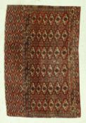 A Bokhara Torba rug, the main panel set with repeating elephant foot motifs on a dark red ground,