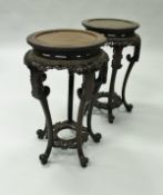 A pair of 19th Century Chinese rosewood urn stands of typical form,