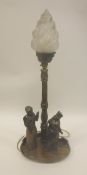 A carved oak table lamp as a flaming torch with figures in Dark Ages costume,