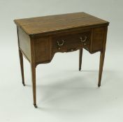 An Edwardian mahogany and inlaid games table with fold-over top and various drawers and