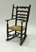 A 19th Century Dales ash ladder back rush seated wingback chair on turned legs and rockers 90 cm