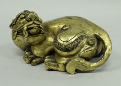 A Chinese Han style gilt bronze figure of a crouching beast snarling its tongue protruding 16 cm