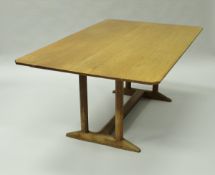 A Gordon Russell oak dining table, the plain plank top of rectangular form with canted corners,