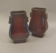 A pair of Chinese sang de boeuf square baluster shaped vases raised on a square foot,