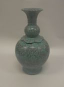 A Chinese speckled turquoise glazed vase of gourd form with studded panelled shoulders and flaired