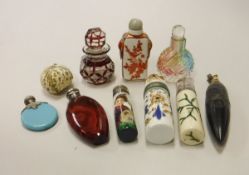 Three cylindrical scent bottles two with silver mounts, one in an Imari pattern,