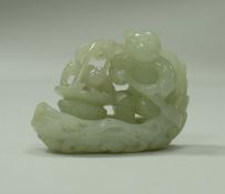 A Chinese mutton fat jade figure of a man in a boat with basket of peaches, all over carving,