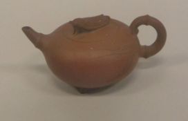 A Chinese Yixing teapot, the lid decorated in relief with a cricket,