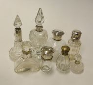 A collection of eight silver mounted dressing table scent bottles and a similar brass mounted