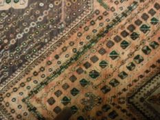 A Shiraz carpet, the central panel set with a diamond shaped medallion on a pale pink ground,