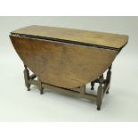 An 18th Century oak oval gate-leg drop-leaf dining table with single end drawer on baluster turned