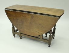 An 18th Century oak oval gate-leg drop-leaf dining table with single end drawer on baluster turned