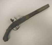 A 19th Century Indian flintlock pistol with white metal embellishments and turquoise bead to the