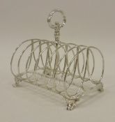 A Victorian silver six section toast rack, raised on stylised claw feet (by R & S Garrard & Co.