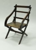 A circa 1900 child's oak ladder back elbow chair on X frame base,
