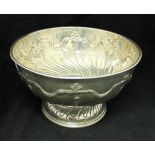 A Victorian silver punchbowl with embossed decoration raised on a circular foot (by James Deakin &