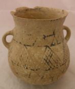 An ancient near Eastern pottery buffware two handled jar with geometric design flanked by two plain