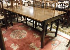 A mahogany rectangular dining table on square moulded supports united by a centre stretcher in the