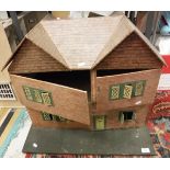 An early to mid 20th Century dolls house with printed paper tile and brick work and painted tin