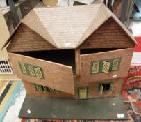 An early to mid 20th Century dolls house with printed paper tile and brick work and painted tin