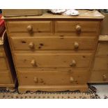 A modern pine chest of two short over three long drawers to bracket feet