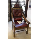 An oak chair in the gothic style with red buttoned leather back inscribed "Elizabeth II silver