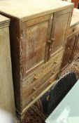 An early 20th Century limed oak bedroom cabinet with two doors above three drawers on splayed