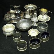 A collection of small silverwares including a pair of embossed silver peppers, two small cream jugs,