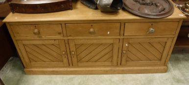 A late Victorian pine dresser with three drawers over three cupboard doors