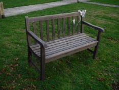 A modern carved teak bench seat of slatted construction