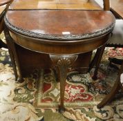 An early 20th Century burr walnut veneered foldover card table of demi lune form