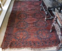 An Afghan rug, the central panel set with repeating pattern on a dark red ground,