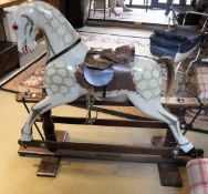 A 20th Century dapple grey painted rocking horse on standard oak base