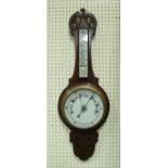 WITHDARWN A late Victorian mahogany cased and carved aneroid barometer / thermometer and a brass